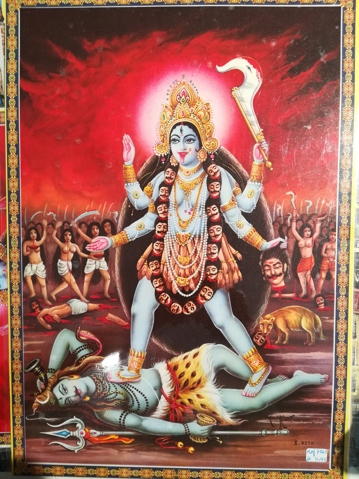 Poster plastificado da Deusa Kali com 4 mãos segurando foice e cabeça degolada, pisando o Deus Shiva, tamanho 45x30 cm.