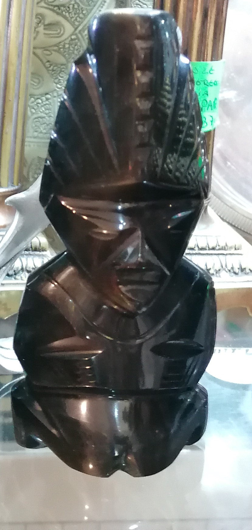 Escultura em pedra labradorite de tamanho médio representando um homem olmeca ajoelhado novo.