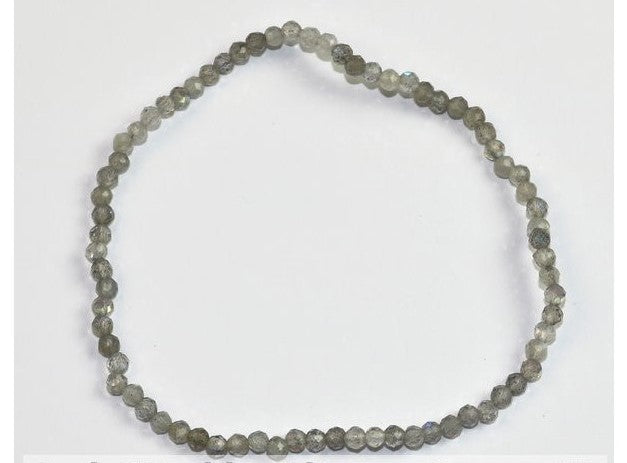 Pulseira infantil elástica feita com pequenas contas redondas e polidas de pedra natural labradorite com reflexos acinzentados e azulados.