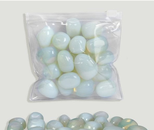 Pedra rolada de Opalite com brilho opalescente e tons azulados, destacando a sua transparência mística