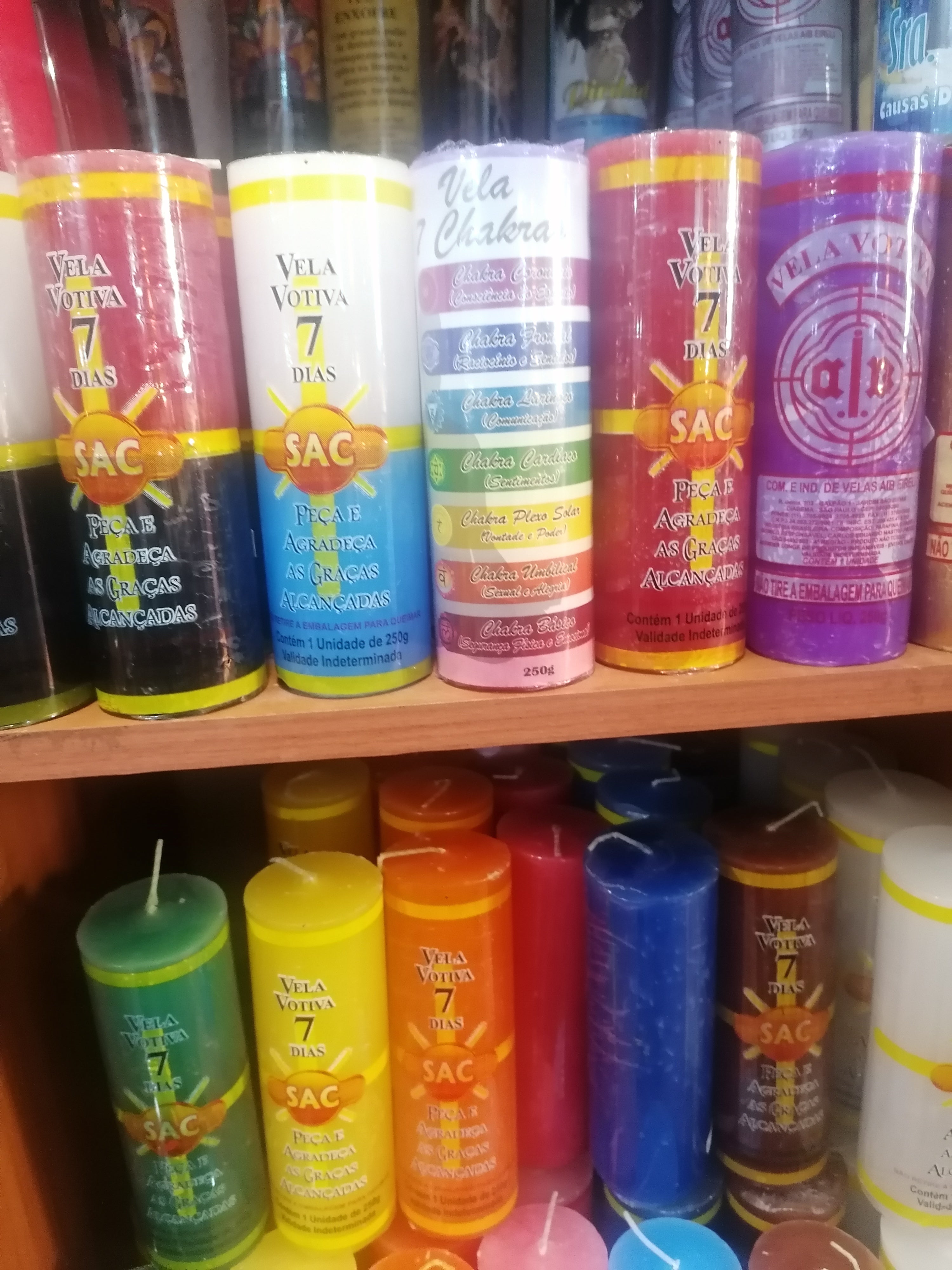Alinhamento de velas esotéricas de várias cores para rituais e ativações espirituais.