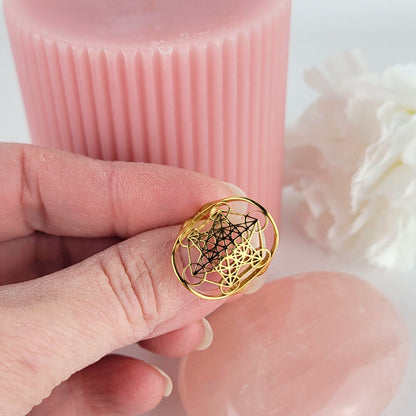 Detalhe de anel místico Metatron banhado a ouro 18K ajustado no dedo para meditação.