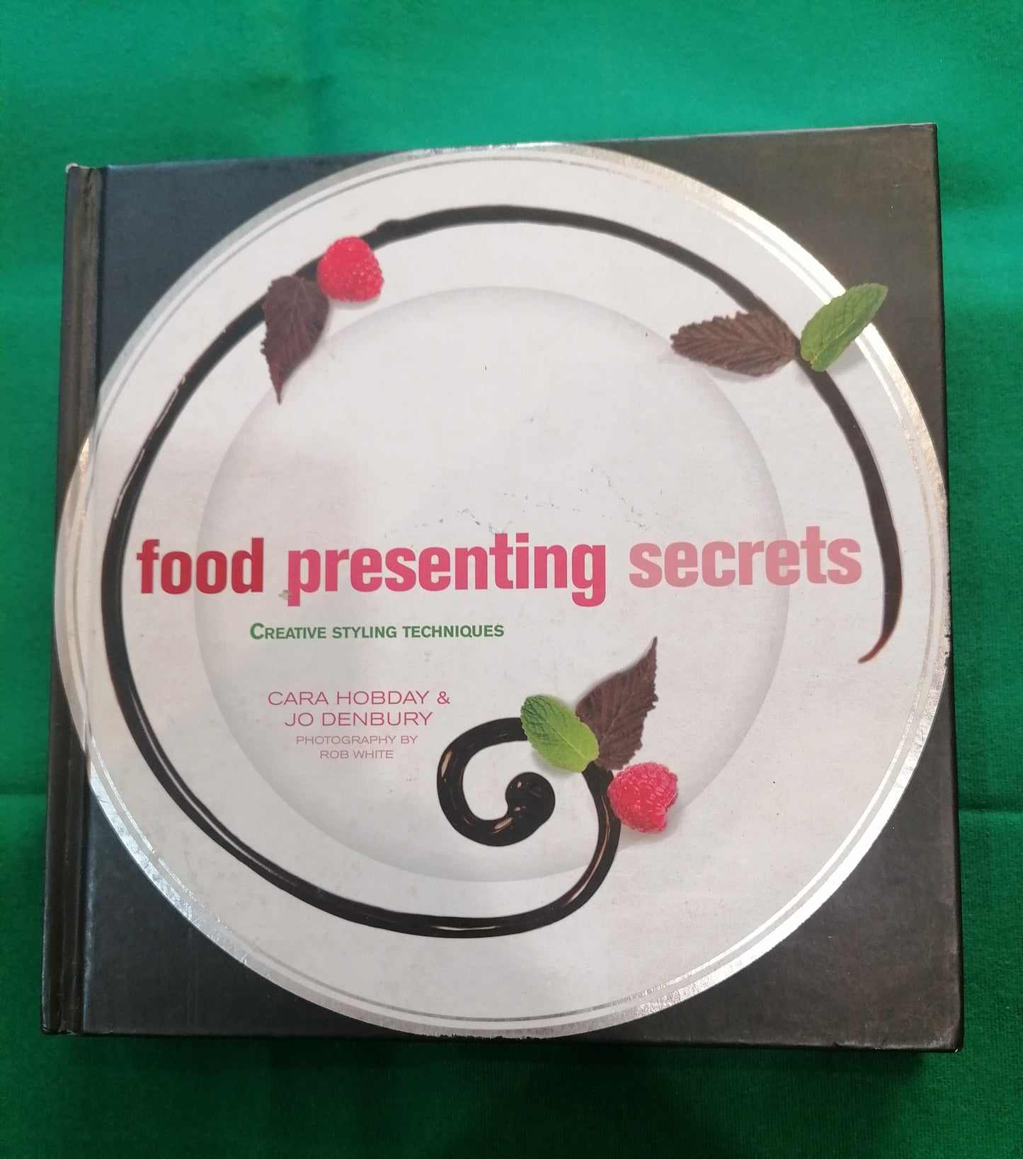 Livro técnico de Food Styling Food Presenting Secrets de Cara Hobday, capa com prato decorado profissionalmente.