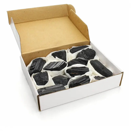 Pedra de Turmalina Negra Bruta natural de 150g a 190g com estrias características sobre fundo claro.