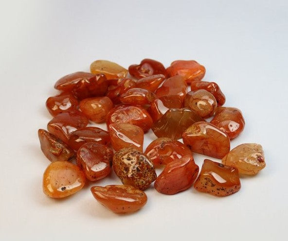 Pedra rolada de Cornalina com tons laranja vibrantes e polimento brilhante para energia e coragem
