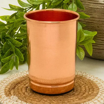 Copo de cobre puro liso artesanal com 300 ml de capacidade e acabamento pesado em fundo neutro.