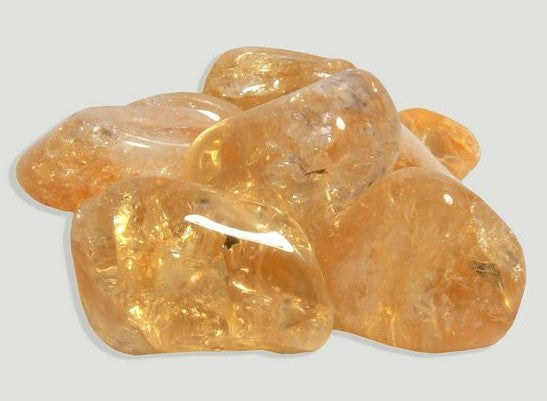 Pedra de Citrino média rolada com tom dourado intenso e alta transparência para decoração e energia."