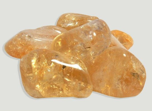 Pedra de Citrino média rolada com tom dourado intenso e alta transparência para decoração e energia."