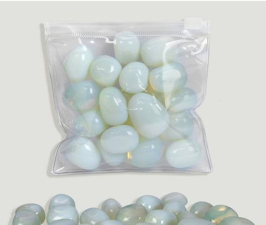 Pedra rolada de Opalite com brilho opalescente e tons azulados, destacando a sua transparência mística
